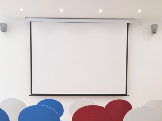 Rotee, blaue und Weiße Stühle vor einer Leinwand