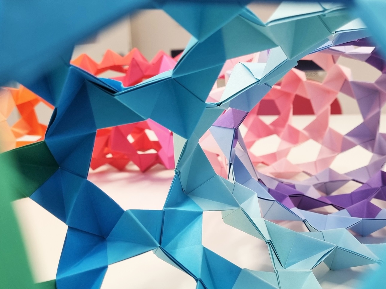 Blick in einen Origami-Torus mit regenbogenfarbenem Farbverlauf